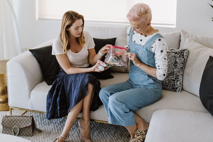 Jessica Rowe holding her cat-themed beauty bag and showing her favourite makeup products
