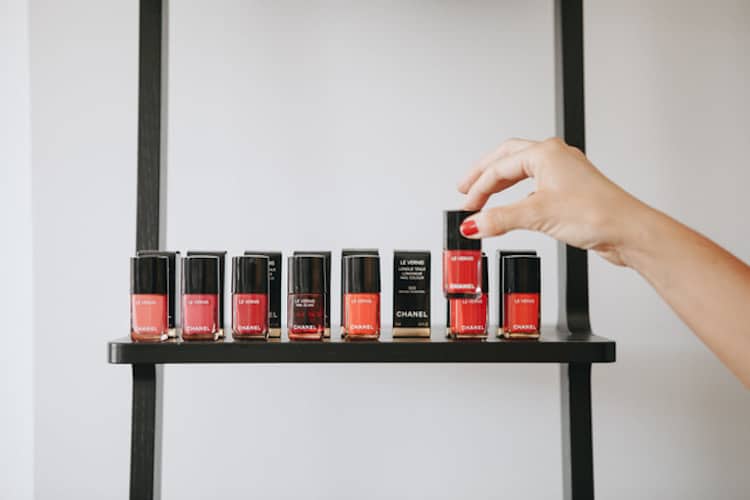 Array of bright nail polish bottles in pink, coral, turquoise and aqua shades displayed against a white background