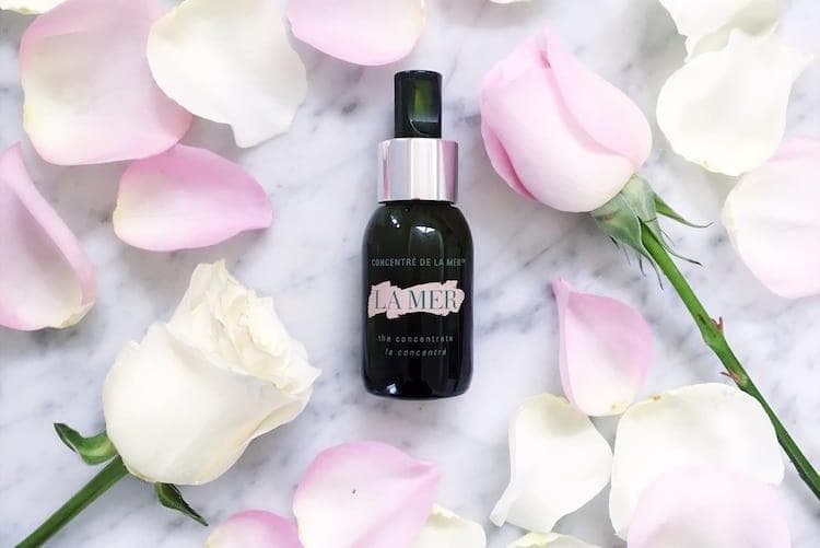 La Mer The Concentrate in deep green glass bottle displayed with skincare products