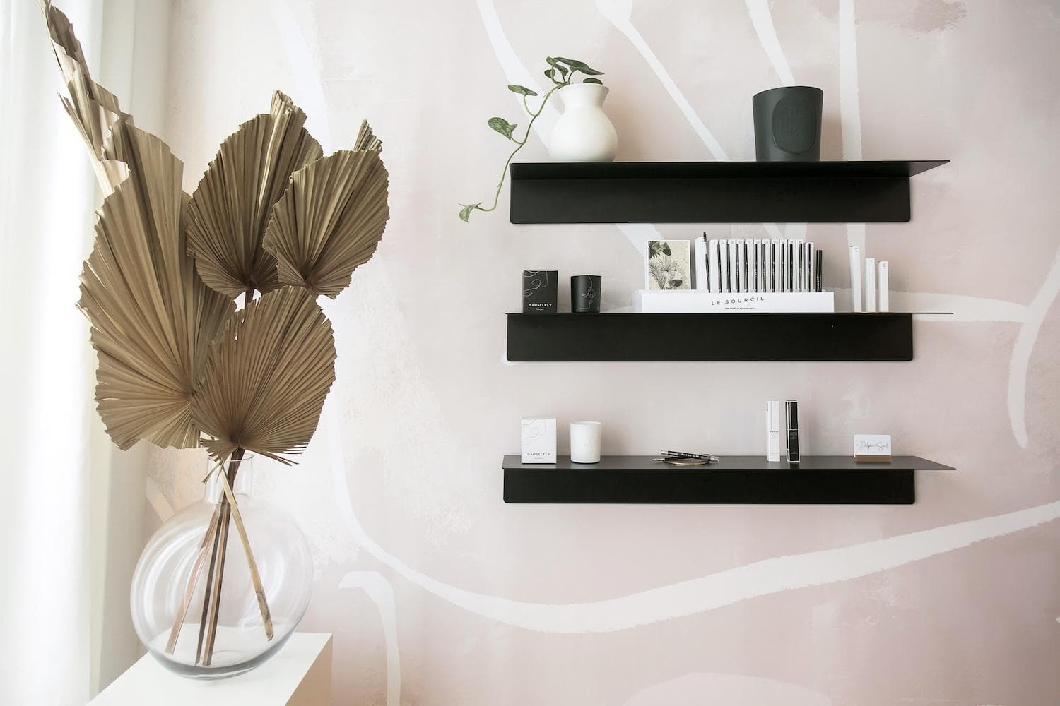 Delphine Sorel salon interior with beige and grey palette, half-moon mirror, and preserved floral arrangements