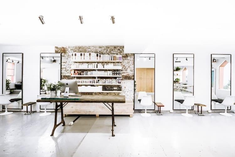 Modern minimalist hair salon interior with whitewashed walls, exposed brick and natural light at Edwards and Co Melbourne
