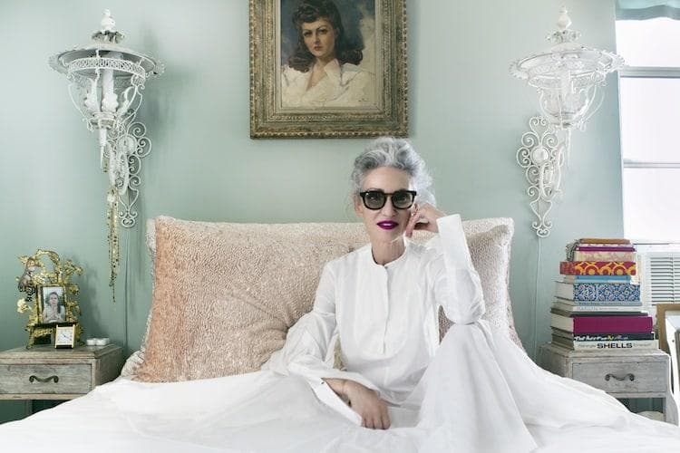 Linda Rodin with grey hair wearing minimal makeup and red lipstick, casual styling