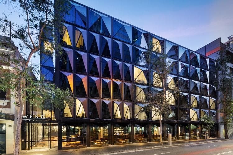 Modern hotel lobby with lush green plants and sleek glass architecture at West Hotel Sydney