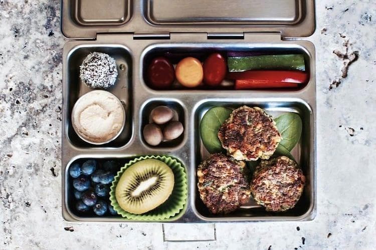 Overhead flat lay of fresh superfoods including avocado, blueberries, coconut water and protein powder on marble surface