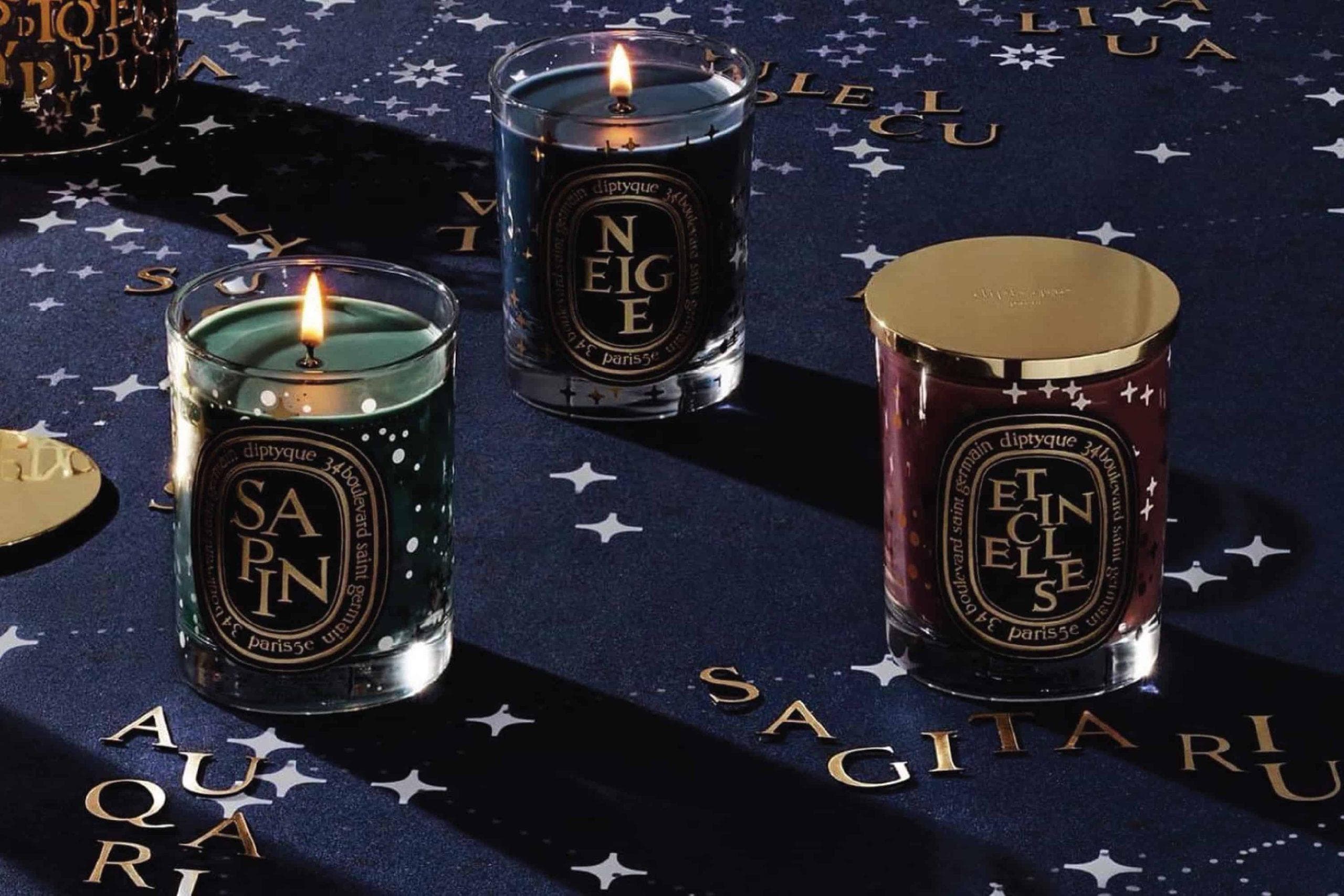 Luxury Christmas candles and fragrances including Diptyque Sapin and Jo Malone Midnight Musk displayed with festive styling