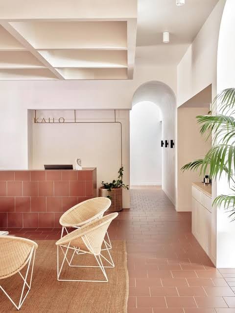 Terracotta-tiled reception, rattan chairs and an arched corridor at KAILO Wellness Medispa, Fortitude Valley