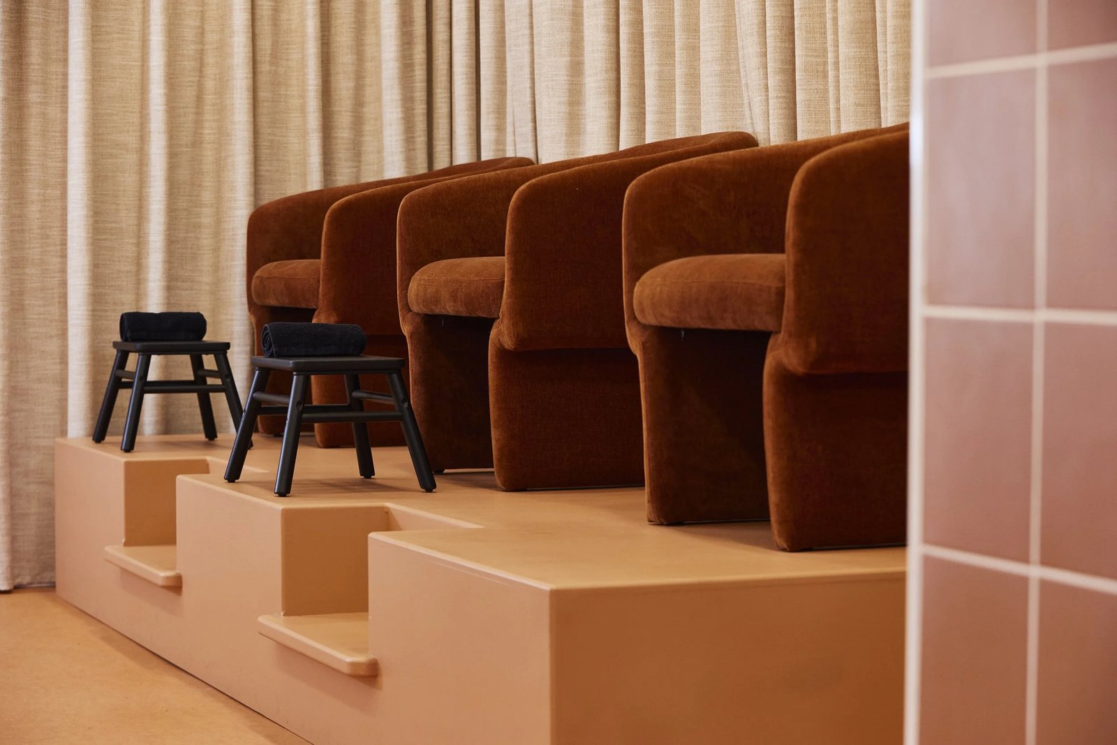 Rust velvet pedicure chairs by Palomar Rowe on a tiered platform at Painted, Darlinghurst