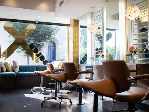 Tan leather styling chairs and geometric pendant lights at Salon X, Paddington