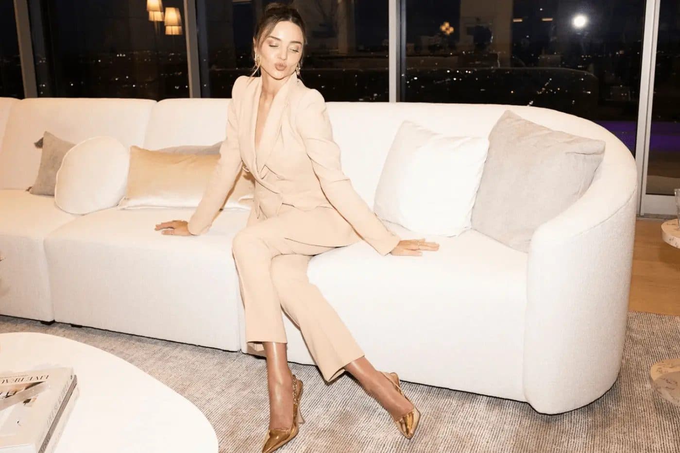 Miranda Kerr in a cream suit on a sofa for the Beautiful Inside by Beauticate podcast with Sigourney Cantelo
