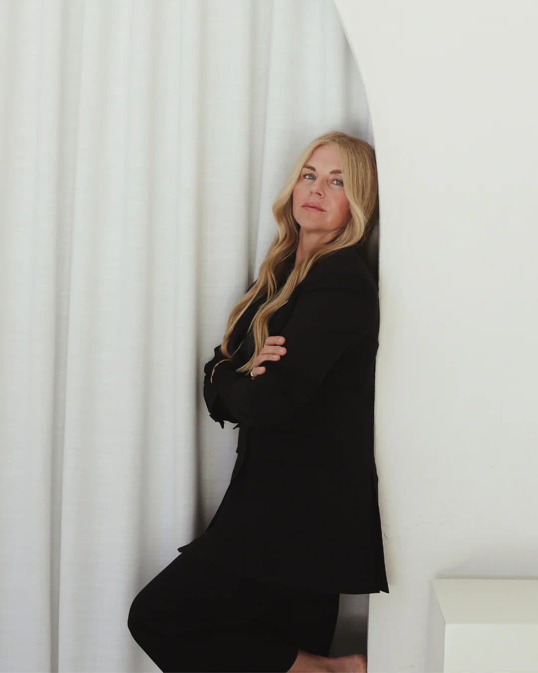 Mukti, founder of Mukti Organics, in a black blazer against soft curtains, for Beautiful Inside by Beauticate