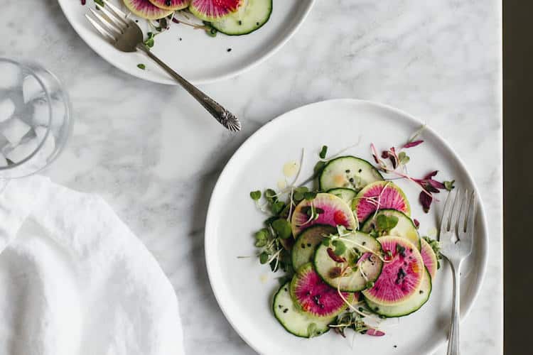Colourful spread of fresh berries, leafy greens, whole grains and protein on a marble table