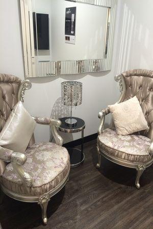 Elegant waiting area at Dr Anh medispa with tufted wing back chairs and crystal lamp