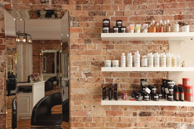 QUE Colour salon interior with exposed brick walls and product shelves