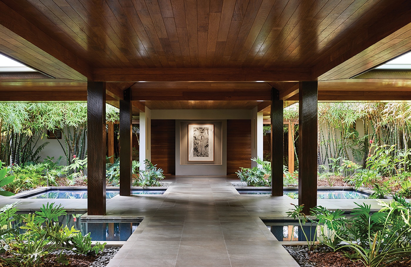 Timber-lined walkway through Spa qualia's tropical garden courtyard, flanked by reflection pools