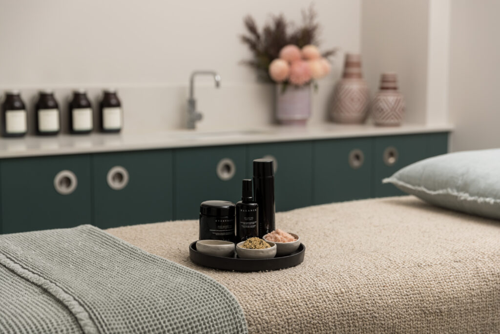 Treatment tray of botanical products set out on a massage table at Eléme Day Spa