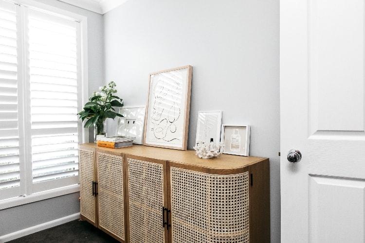Sigourney beside the Embrace sideboard in her home office with organised beauty products inside