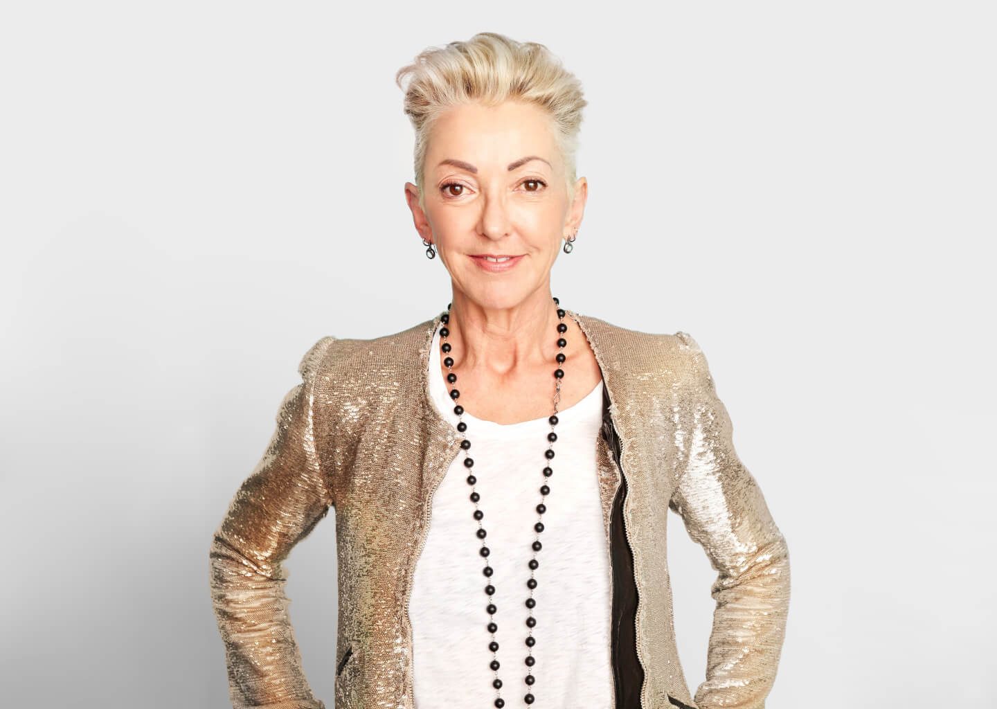 Jane Wurwand, founder of Dermalogica, in a gold jacket against a soft grey background