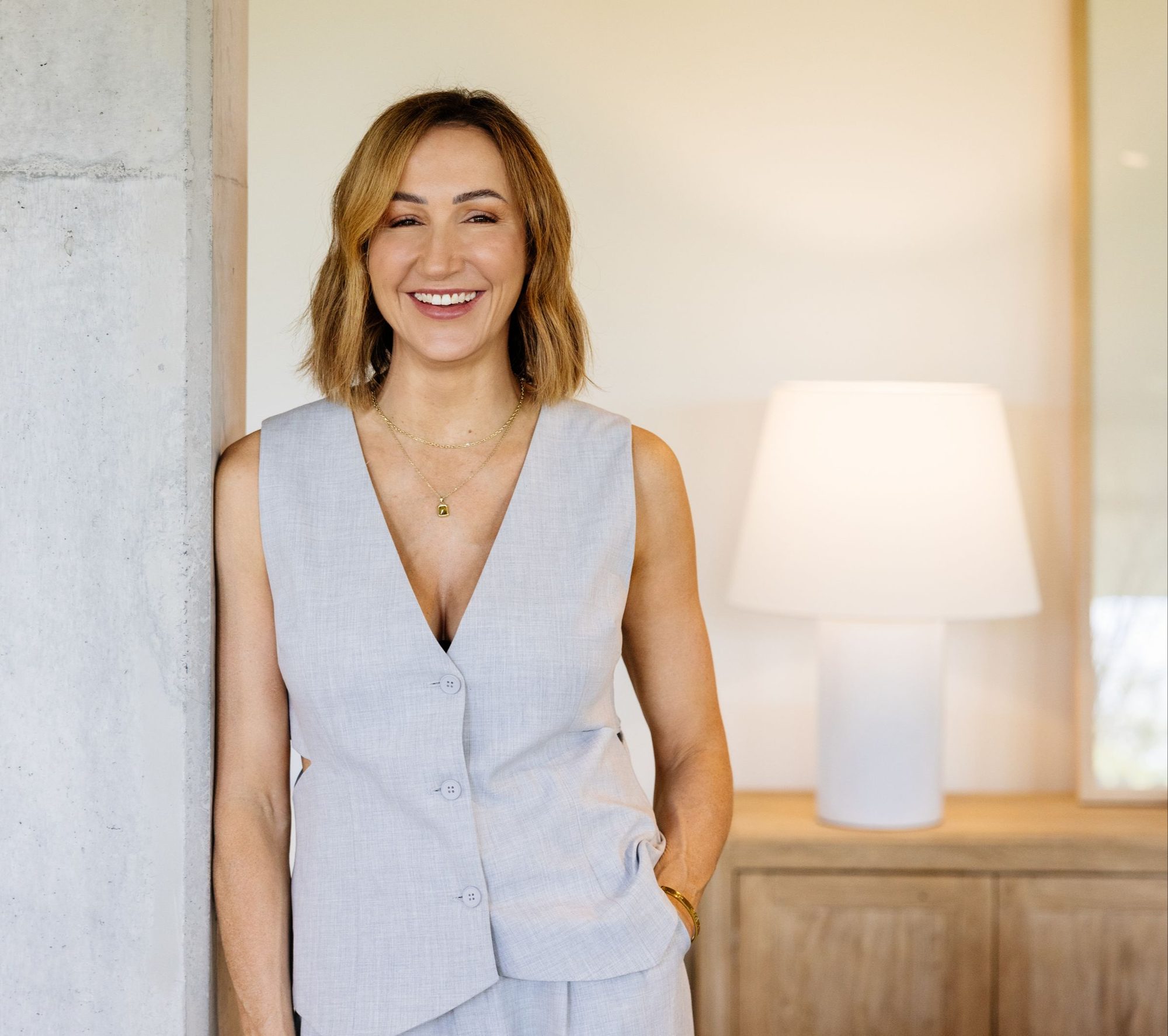 Jessica Maguire leaning against a marble column in a sunlit room, for Beautiful Inside by Beauticate