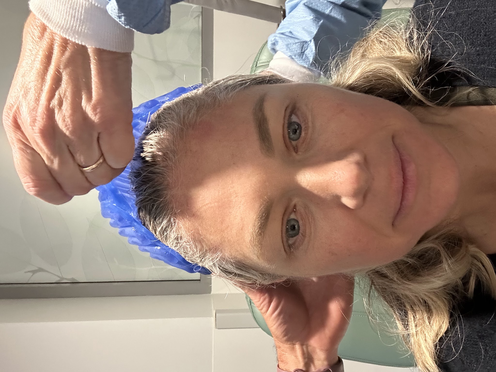 A nurse fitting the cold cap onto Colette's head before a chemotherapy session